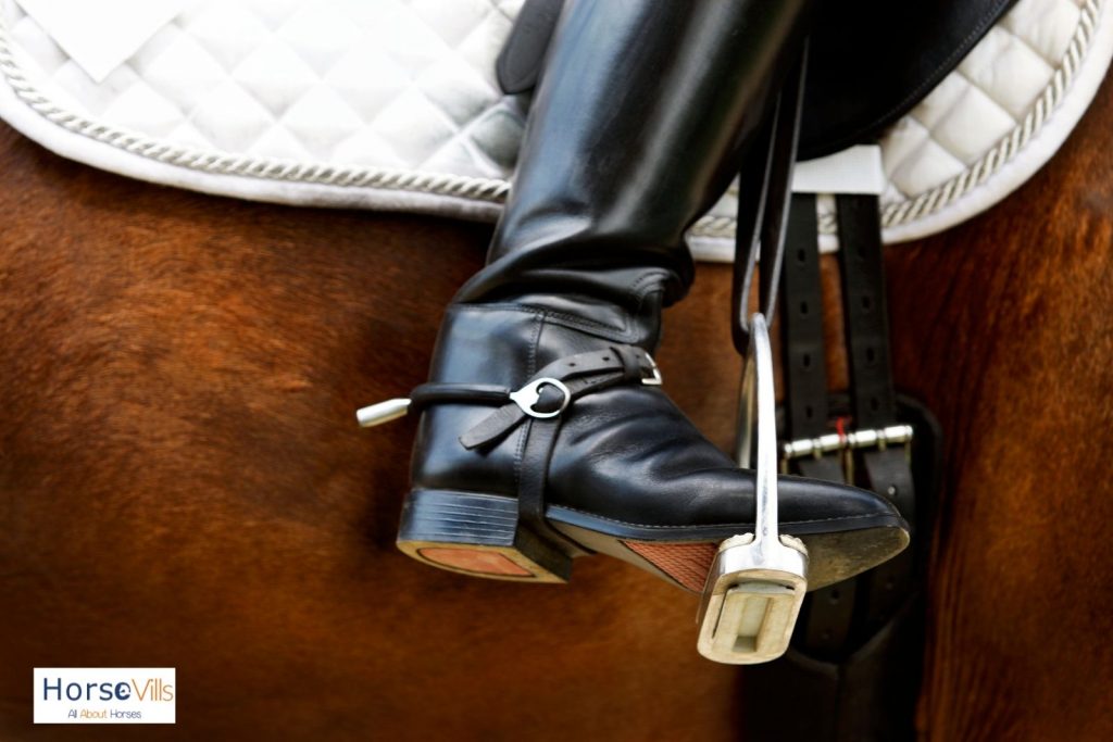 a shiny and polished black leather riding boot