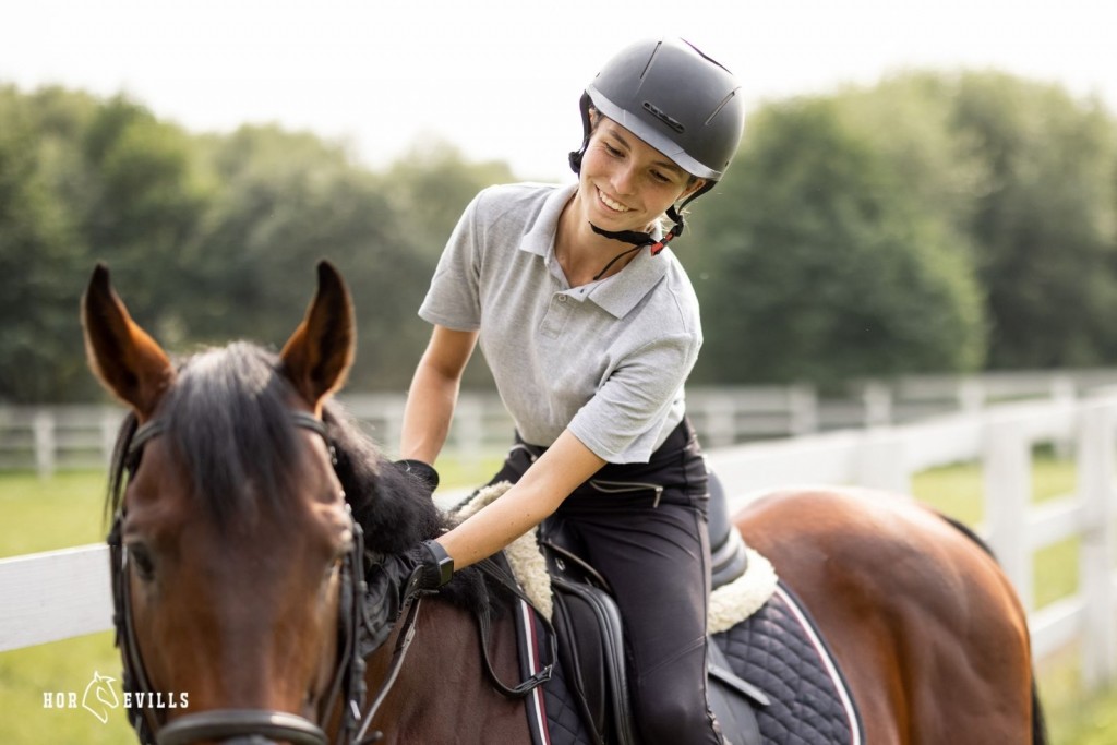 pretty lady riding a horse and wearing a helmet
