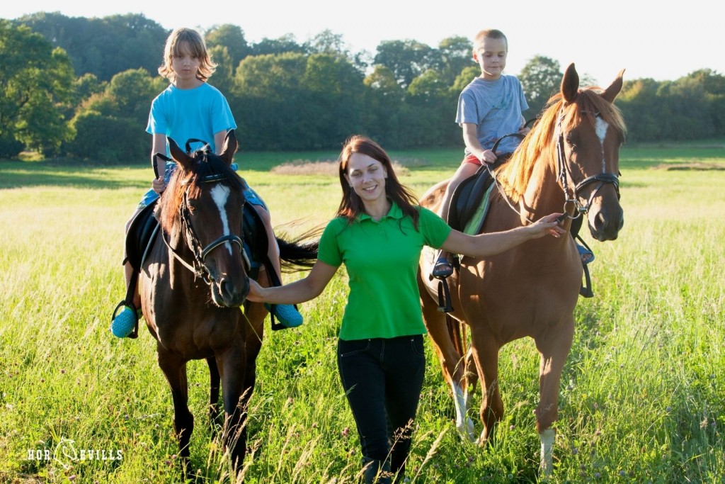 trainer and 2 kids riding horses